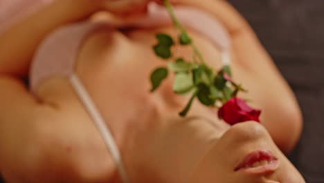 Valentines-Day-Concept:-An-attractive-woman-dressed-in-sexy-lingerie-sensually-caresses-her-beautiful-body-with-a-red-rose