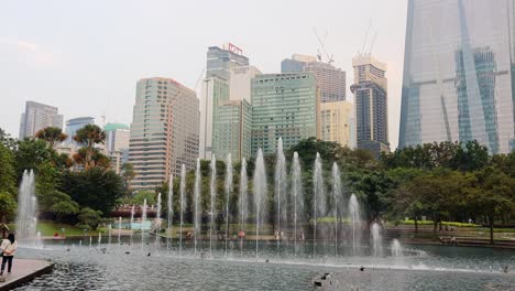 Decorative-water-fountains-at-Suria-KLCC-Park-during-the-evening,-Kuala-Lumpur,-Malaysia