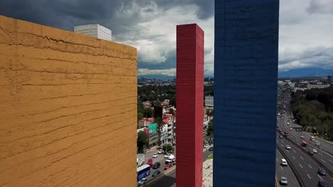 Upward-shot-during-a-cloudy-and-clear-afternoon-of-the-Satelite-towers,-ending-with-the-panoramic-shot-of-Mexico-City