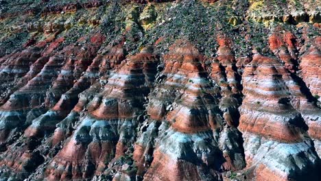 Aerial-view-of-the-beautiful-striped-strata-in-the-ground,-forming-colorful-rainbow-patterns