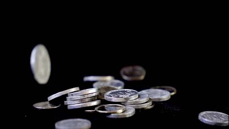 Falling-money-coin-on-black-background