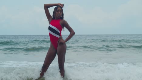 On-a-north-coast-beach-in-Trinidad,-a-young-girl-in-a-Trinidad-flag-bikini-is-on-the-Caribbean-island