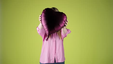 Mujer-Bonita-Rubia-Sosteniendo-Un-Globo-Morado-En-Forma-De-Corazón,-Humor-De-San-Valentín,-Foto-De-Estudio-Con-Pantalla-Verde