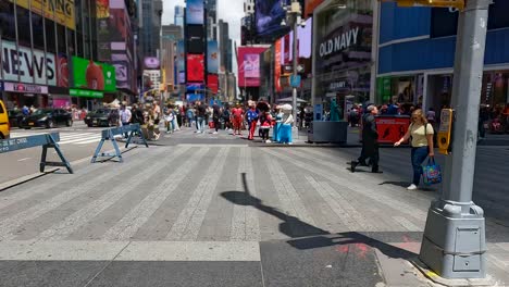 Weiße-Mollige-Frau-Mittleren-Alters-Mit-Sonnenbrille,-Die-Mit-Einer-Einkaufstasche-Auf-Dem-Times-Square-Vor-Leuten-Läuft,-Die-Verschiedene-Disney--Und-Marvel-Kostüme-Tragen