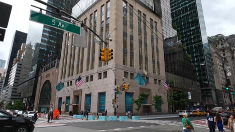 Fußgänger-überqueren-Den-Zebrastreifen-An-Der-5-Avenue-In-New-York,-Und-Die-Kamera-Schwenkt-Nach-Oben-Zu-Den-Wolkenkratzern-In-New-York-City