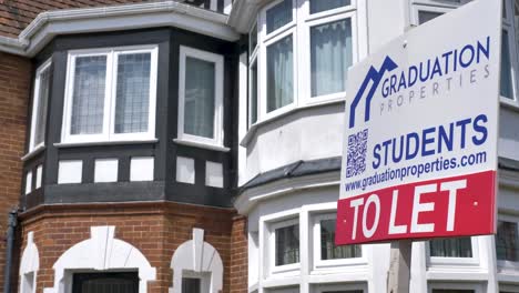 Estate-agent-sign-for-student-properties-to-let-in-front-of-brick-building-with-greenery,-Exeter-Devon-UK,-June-2024