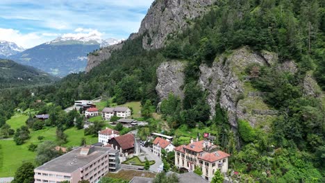 Rothenbrunnen,-Suiza-Con-Exuberante-Vegetación,-Montañas-Y-Edificios-Pintorescos,-Vista-Aérea