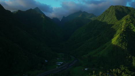 Teahupoo-Tahiti-French-Polynesia-aerial-drone-view-sunset-light-towering-mountain-peaks-valley-town-villageincredible-dark-clouds-island-landscape-Moorea-Bora-Bora-Papeete-forward-pan-up