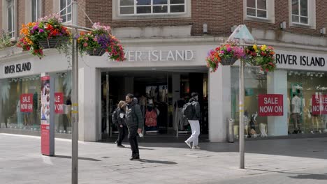 Exterior-of-large-River-Island-shop-facade-with-floral-decorations,-Exeter-Devon-UK,-June-2024