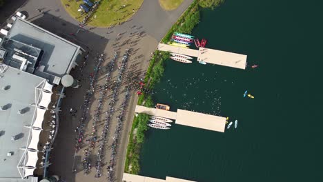 Top-angle-shot-of-Triathlon-at-Dorney-lake,-triathletes-are-beginning-the-race-and-swimming-towards-the-transition-area