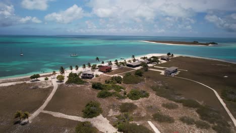 Dos-mosquises-biology-station-with-turquoise-waters-and-scattered-buildings,-aerial-view