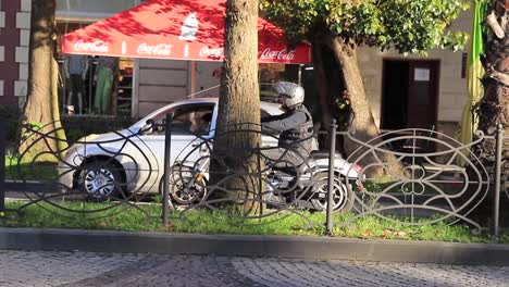 Captura-La-Vida-Cotidiana-En-Batumi,-Georgia,-Presentando-Una-Pequeña-Calle-Con-Tráfico-De-Automóviles-Y-Una-Motocicleta-En-Una-Señal-De-Alto,-Lo-Que-Ilustra-El-Concepto-De-Rutina-Urbana-Y-Cultura-Local.