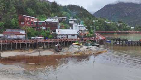 Drohnenaufnahme-Eines-Erhöhten-Weges-Entlang-Der-Küstengemeinde-Caleta-Tortel-In-Chile,-Häuser-Und-Menschen