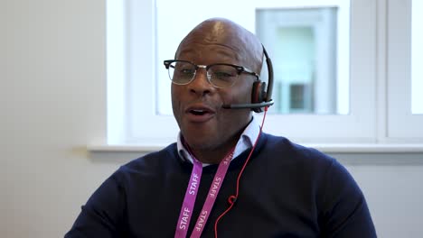 Front-Portrait-Of-Black-Man-Happily-Working-As-Customer-Service-Agent