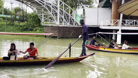 Schwimmender-Markt-Mit-Holzboot,-Auf-Dem-Touristen-Traditionelle-Thailändische-Gerichte-An-Marktständen-Probieren