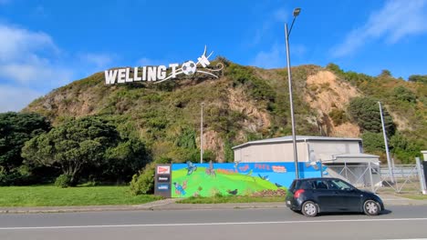 Scenic-view-of-Windy-Wellington-landmark-sign-on-hill-and-predator-free-mural-on-Miramar-Peninsula-in-capital-city-of-Wellington,-New-Zealand-Aotearoa