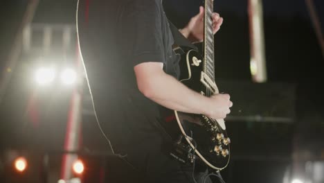 Close-up-view:-Man-plays-electric-guitar-on-stage-during-performance