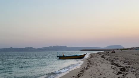 Fischerboot-Erreicht-Den-Sandstrand-Im-Sonnenuntergang,-Goldene-Zeit,-Dämmerung-Im-Sommer,-Panoramalandschaft-Des-Küstendorfs,-Landschaft,-Tropische-Insel,-Reisen-Im-Iran,-Saudi-Arabien,-Kultur,-Natur,-Oman