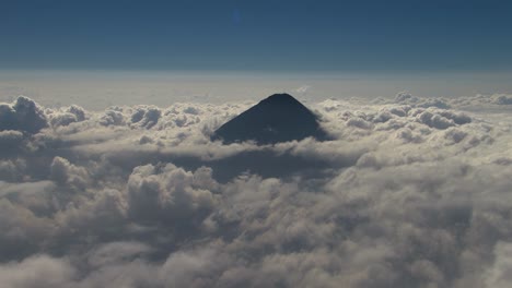 Volcán-De-Agua-In-Antigua-Guatemala-Von-Oben,-Wie-Es-Durch-Ein-Meer-Von-Wolken-Unter-Einem-Heiteren-Blauen-Himmel-Sticht