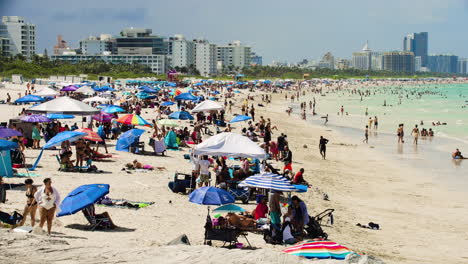 People-Relax-in-the-Shade-of-Beach-Umbrellas-on-Miami-Beach,-Florida