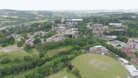 Drone-reveal-of-Exeter-University-and-its-extensive-campus,-showcasing-academic-buildings-and-green-spaces-in-Exeter,-UK