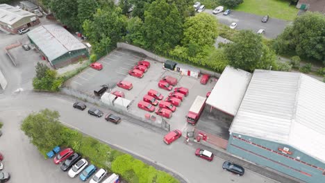 Van-entering-the-Royal-Mail-depot-with-red-delivery-vehicles-parked,-indicating-bustling-logistics-activity,-Tavistock,-Devon,-UK,-June-2024