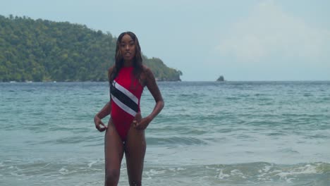 En-El-Caribe,-En-La-Costa-Norte-De-Trinidad,-Una-Joven-Con-Un-Bikini-Con-La-Bandera-De-Trinidad-Está-En-La-Playa.