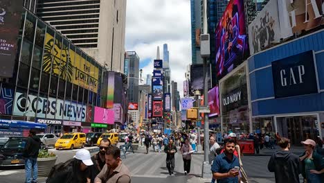 The-camera-moves-through-the-busy-street-of-Times-Square,-capturing-diverse-crowds