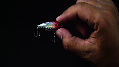 Finger-of-hand-holding-an-artificial-lure