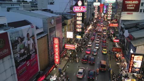 Drone-Establecido-En-La-Carretera-Yaowarat-En-Chinatown-Con-Puestos-De-Vendedores-Ambulantes-De-Vehículos-De-Tráfico-Y-Letreros-De-Neón