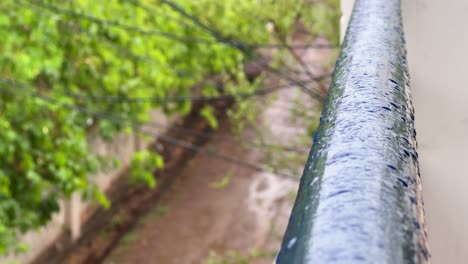 Ambiente-De-Día-Lluvioso,-La-Llovizna-Forma-Gotas-En-La-Barandilla-Del-Balcón