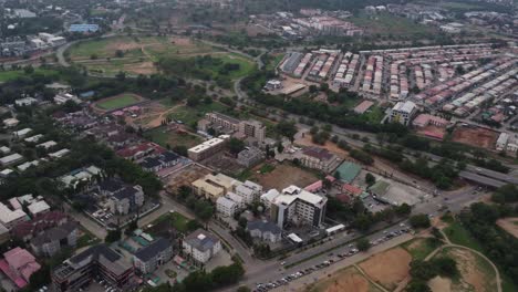 Aerial-flyover-city-with-Housing-area-and-traffic-on-main-street-during-foggy-day