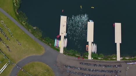 Top-still-shot-of-Triathlon-at-Dorney-lake,-swimmers-group-start-from-the-water