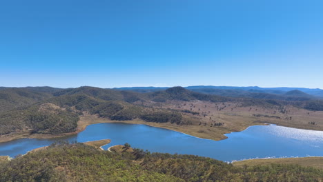 Aerial-across-forested-headlands-and-waters-of-Lake-Cania-on-a-brilliant-fine-day