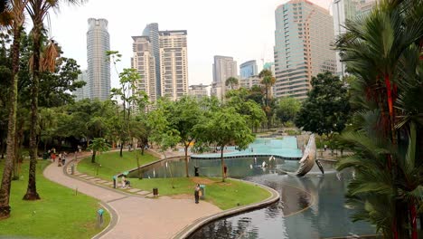 Whale-statute-and-swimming-area-at-Suria-KLCC-Park-wide-angle,-top-down-in-Kuala-Lumpur,-Malaysia-during-the-evening