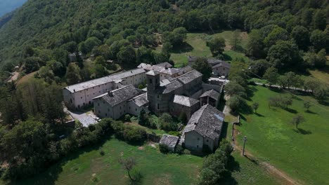 Aerial-Overhead-view-of-the-historic-Novalesa-Abbey,-a-Benedictine-monastery-nestled-in-the-lush-landscape-of-Piedmont,-Turin,-Italy