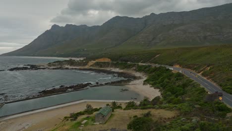 Car-driving-towards-a-quiet-tidal-pool-during-an-overcast-day-near-Cape-Town