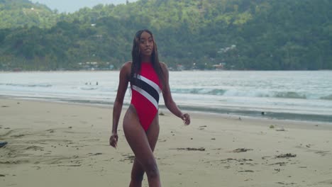 Amid-the-twin-islands-of-Trinidad-and-Tobago,-a-young-African-girl-enjoys-the-beach-in-a-bikini-with-ocean-waves-in-the-background