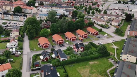 A-residential-neighborhood-with-red-roofed-houses-and-green-surroundings,-aerial-view