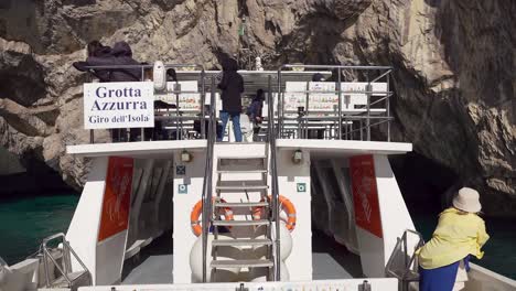 Boat-tour-exploring-the-Green-Grotto-also-known-as-The-Emerald-Grotto,-Grotta-Verde,-on-the-coast-of-the-island-of-Capri-in-the-Bay-of-Naples,-Italy