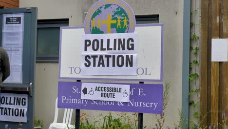 Polling-station-sign-outside-school-with-accessible-route-indication,-Exeter,-Devon,-UK,-June-2024