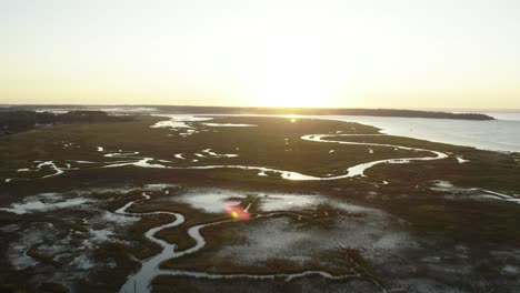 Winding-river-snakes-through-swamp-wetlands-at-sunset-in-Chincoteague-Island-Virginia,-slow-motion