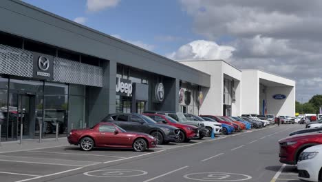 Exterior-of-car-dealerships-featuring-Mazda,-Jeep,-Alfa-Romeo,-Cupra,-Fiat,-Abarth,-and-Ford,-Exeter,-Devon,-UK,-June-2024