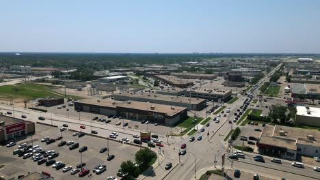 Drone-orbits-Ashley-Furniture-HomeStore-at-Winnipeg-intersection-under-clear-sky