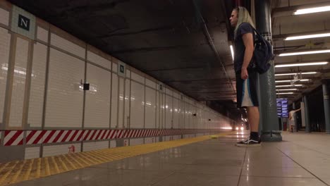 Man-with-Long-Green-Hair-Stands-in-Nevins-Street-Station-as-a-Train-Pulls-In