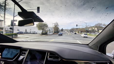 Point-of-view-dashboard-interior-display-of-car-vehicle-driving-through-busy-traffic-intersection-at-lights-in-neighbourhood-street-roads-suburbs-transport-travel