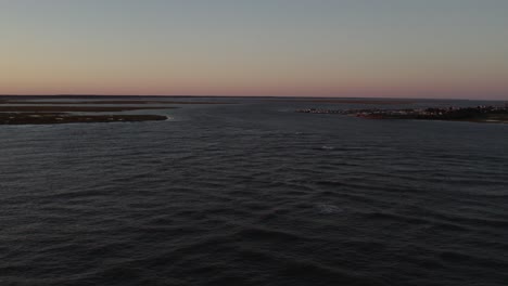 Dusk-glow-of-light-spreads-across-serene-peaceful-sky-in-Chincoteague-Island-Virginia,-slow-motion