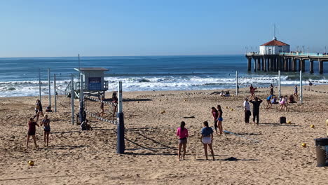 Landschaftsaufnahme-Von-Leuten,-Die-Volleyball-Am-Strand-Von-Manhattan-Mit-Wharf-Pier-Spielen,-Feier,-Freizeit,-Wettbewerb,-Fitness,-Community,-Kalifornien,-USA,-Amerika