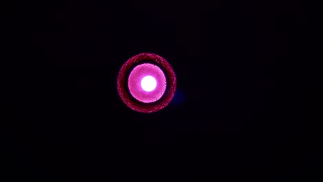 Red,-pink-light-of-a-lamp-in-the-middle-of-the-view,-darkness-around,-static