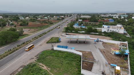 Vista-Aérea-De-La-Autopista-De-Chennai-A-Hosur-Durante-El-Amanecer,-Con-Las-Primeras-Luces-Del-Día-Proyectando-Un-Suave-Resplandor-Sobre-El-Paisaje-Y-Un-Tráfico-Mínimo-En-La-Carretera